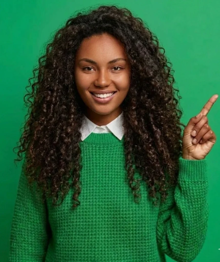 Head shot of a African American woman in a green sweater pointing